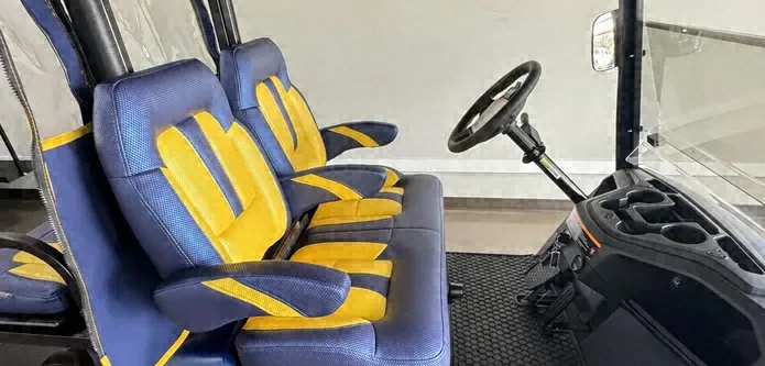 Blue and yellow custom seats on a blue Yamaha golf cart