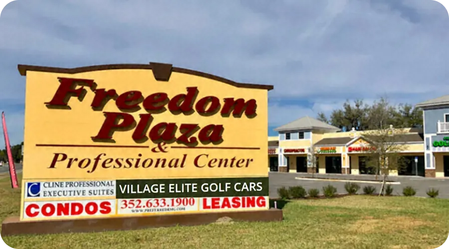 Freedom Plaza & Professional Center sign listing Village Elite Golf Cars