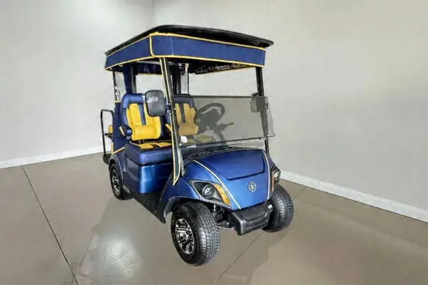 Blue Yamaha golf cart with yellow and blue seats and a navy roof with yellow trim