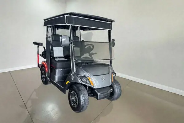 Gray Yamaha golf cart with black seats and a black roof