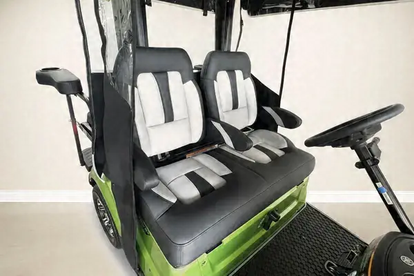 Close-up of white and black seats on a lime green golf cart