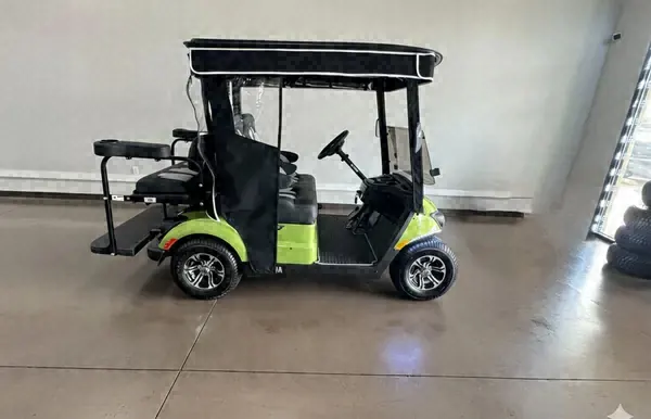 Side view of a lime green Yamaha golf cart with a rear flip seat