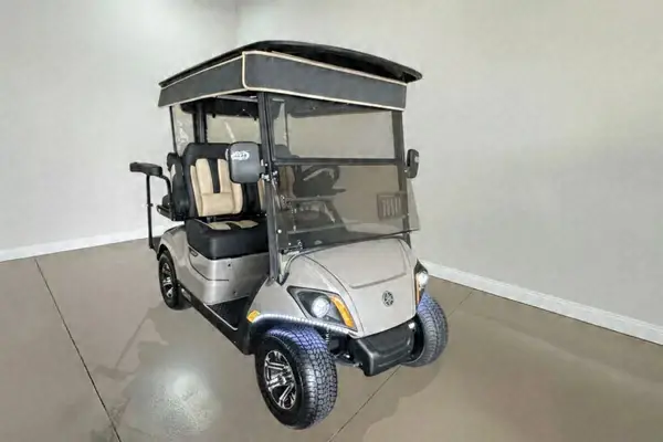 Silver Yamaha golf cart with black and tan seats and a black roof