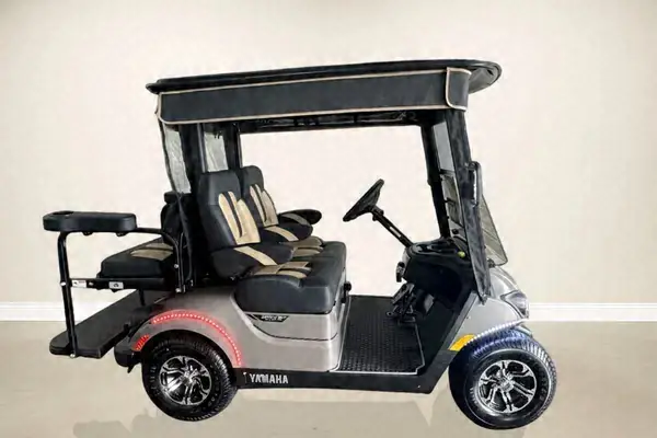 Side view of a silver Yamaha golf cart with black and tan seats