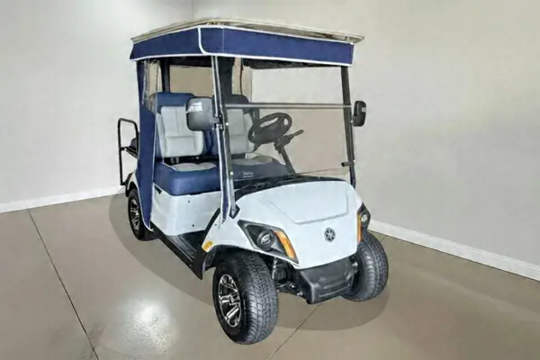 White Yamaha golf cart with blue seats and a navy roof