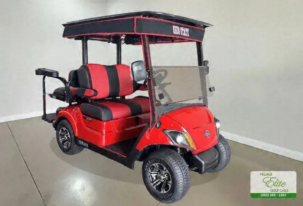 Red Yamaha golf cart with red and black seats and a black roof