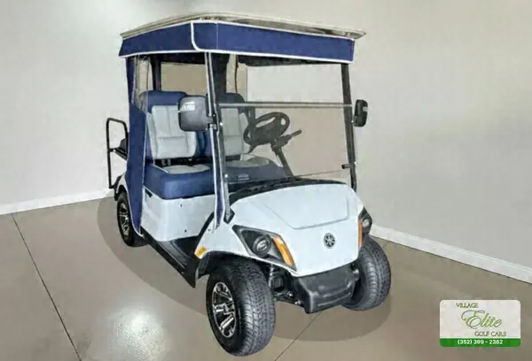 White Yamaha golf cart with blue seats and a navy roof